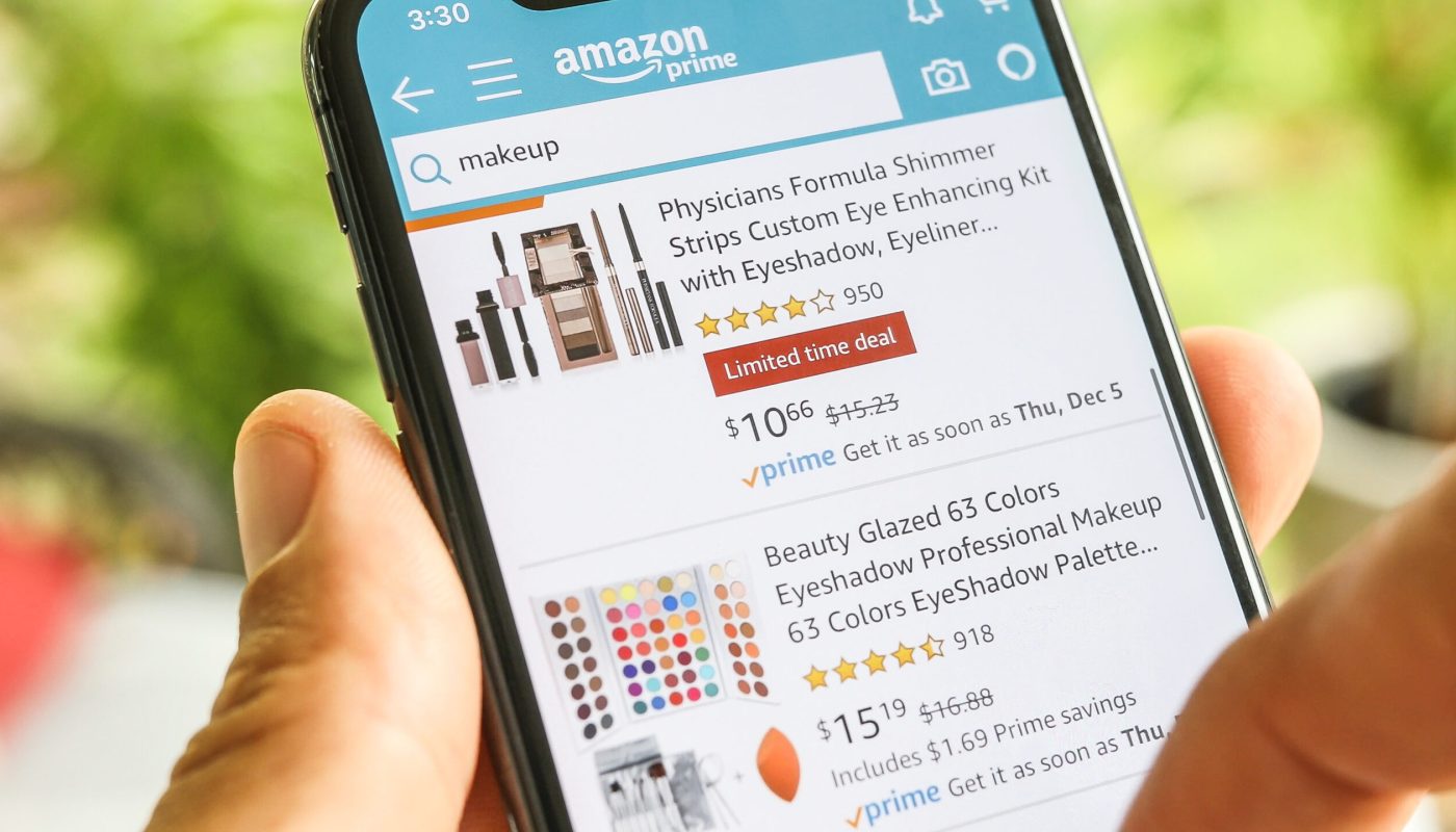 NEW YORK CITY, NY – December 1, 2019: Woman searching for Goods Cosmetics on Amazon app with Mobile Smart iPhone